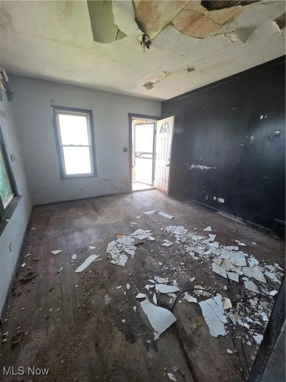 Unfurnished room featuring hardwood / wood-style floors and a textured ceiling