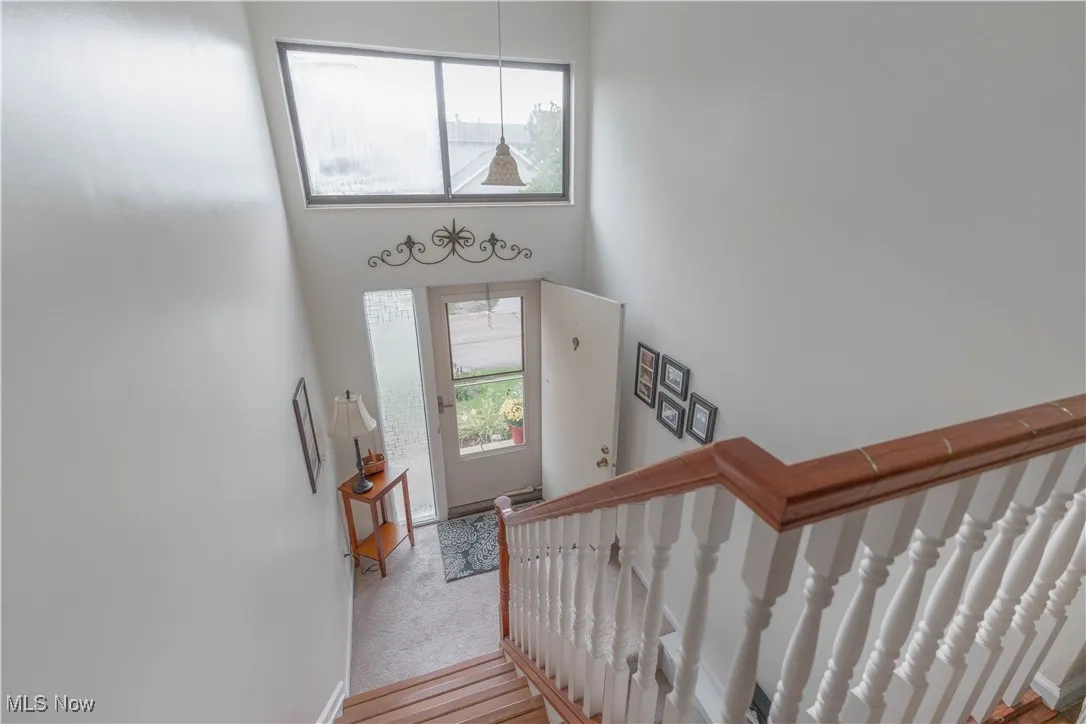 Stairway featuring a towering ceiling and wood finished floors