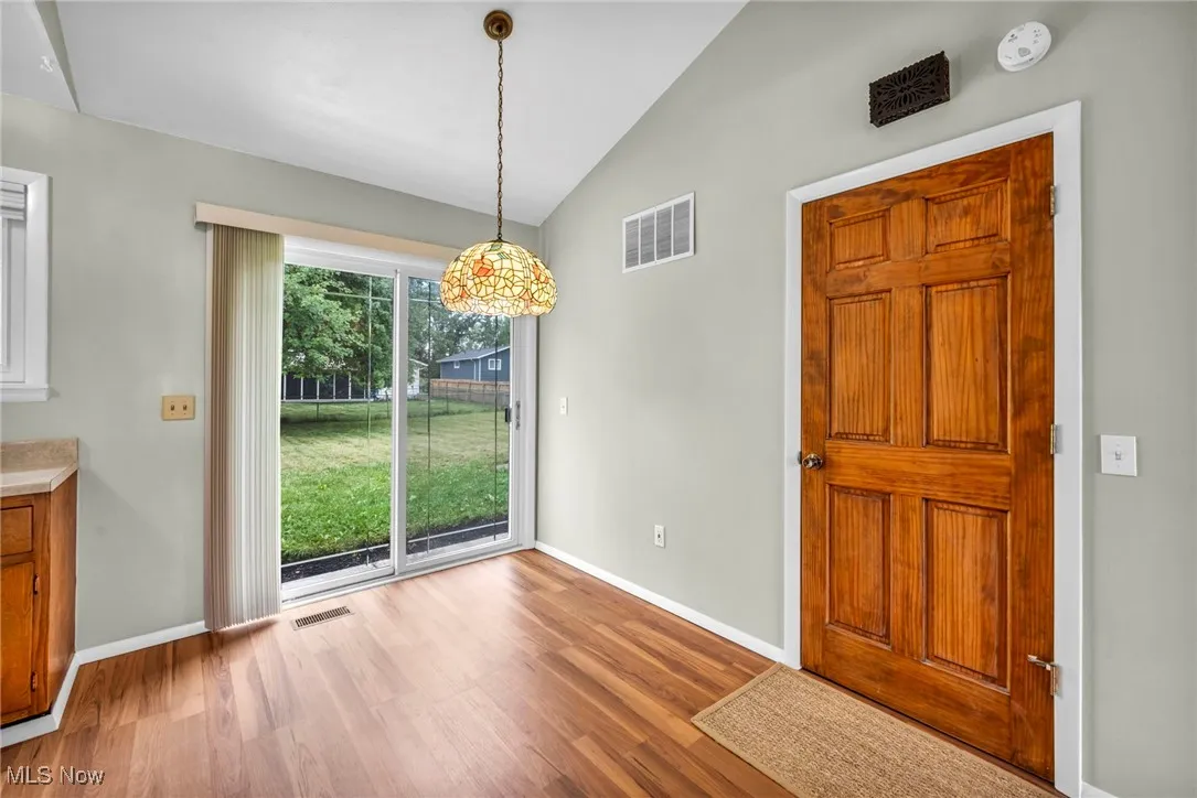 Unfurnished dining area featuring lofted ceiling and wood finished floors