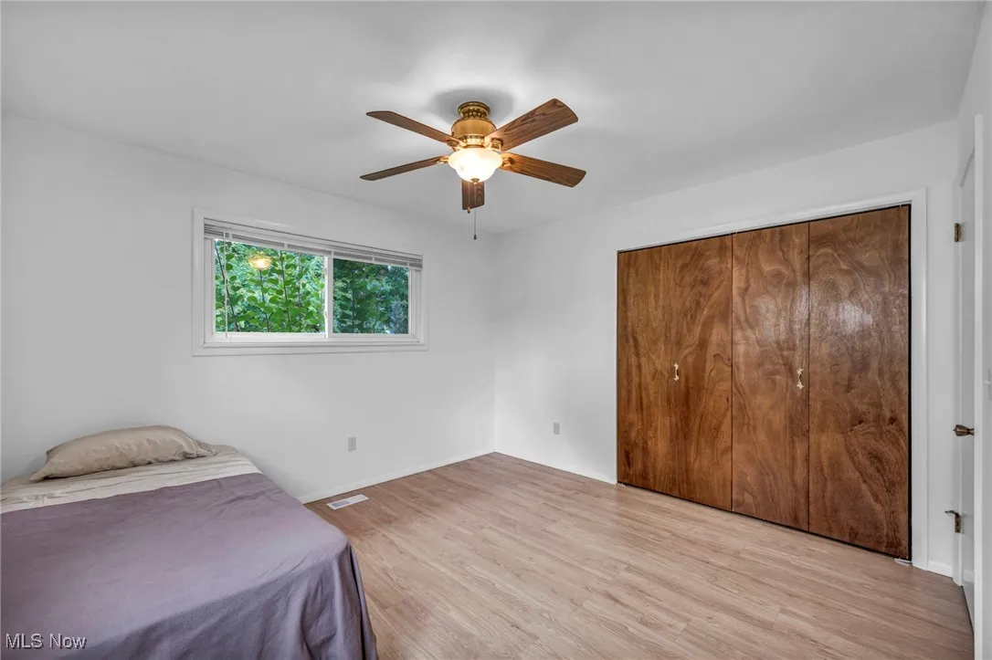 Bedroom featuring light wood-style floors, a ceiling fan, and a closet