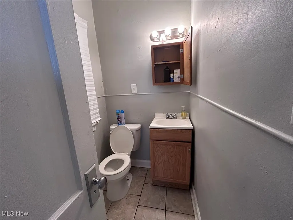 Bathroom featuring tile patterned floors, vanity, and a textured wall