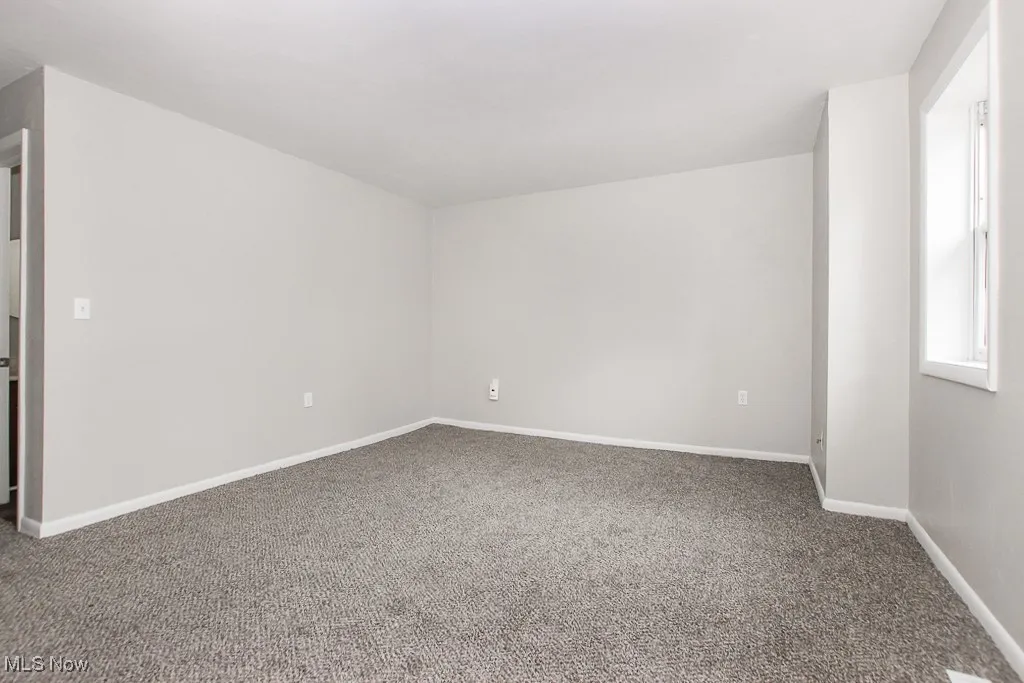 Spare room with carpet and baseboards