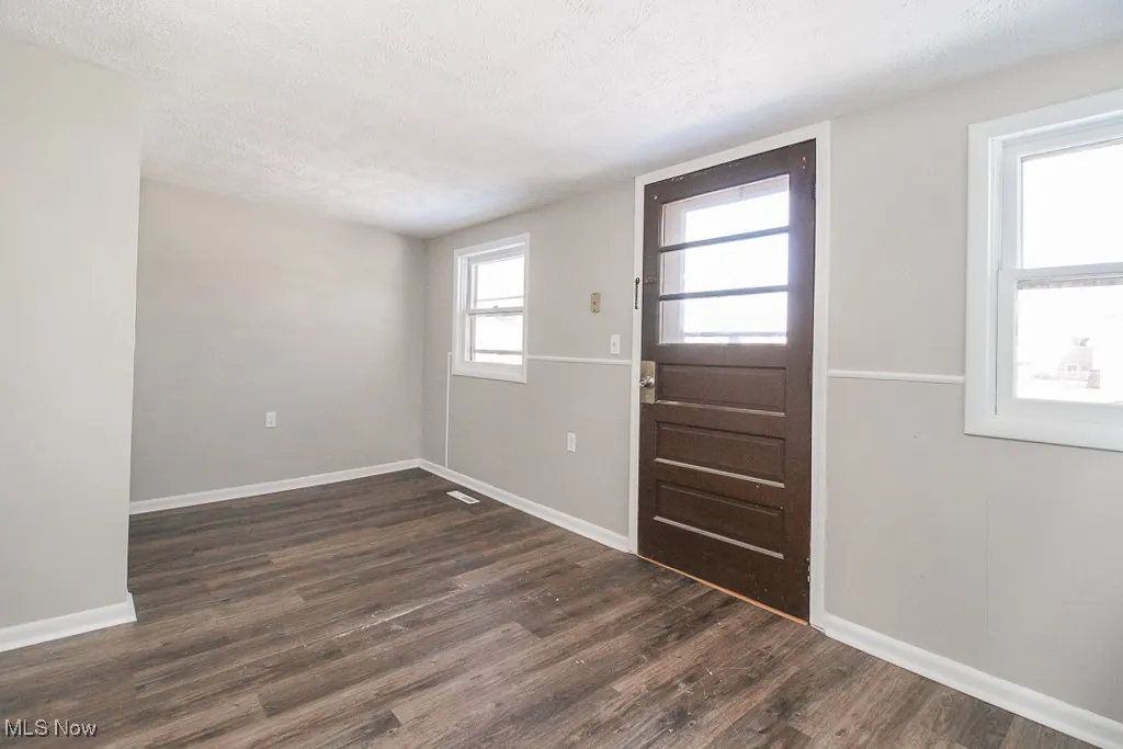Entryway featuring dark wood-style flooring and a textured ceiling