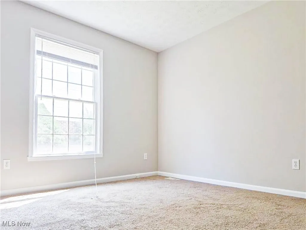 Empty room with carpet flooring and a textured ceiling