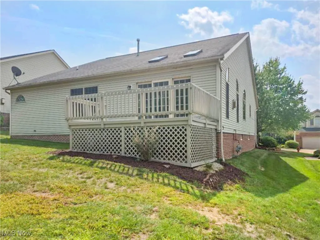 Rear view of property featuring a yard and a deck