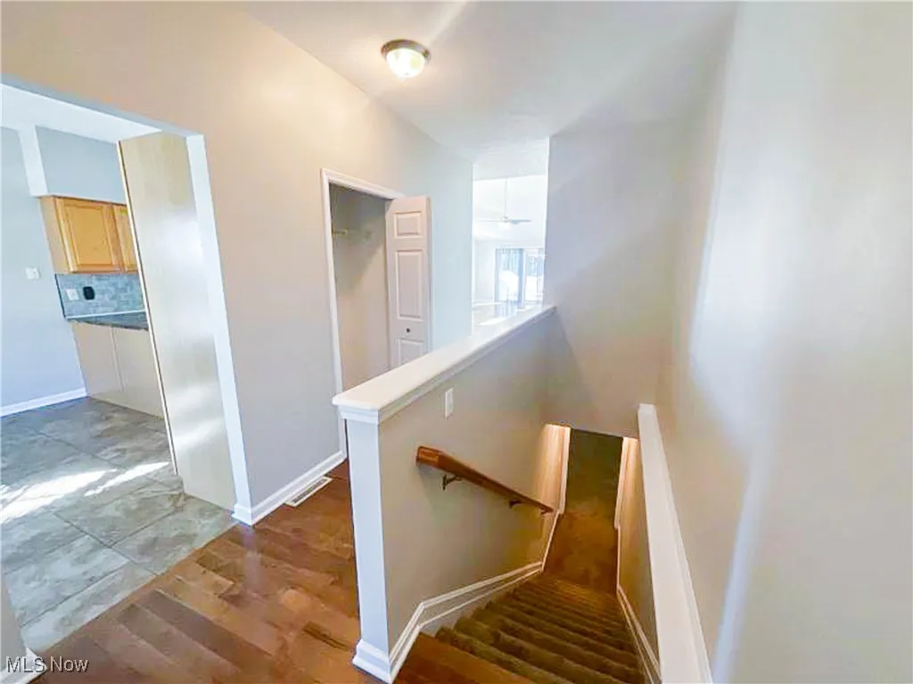 Stairway with baseboards and wood finished floors