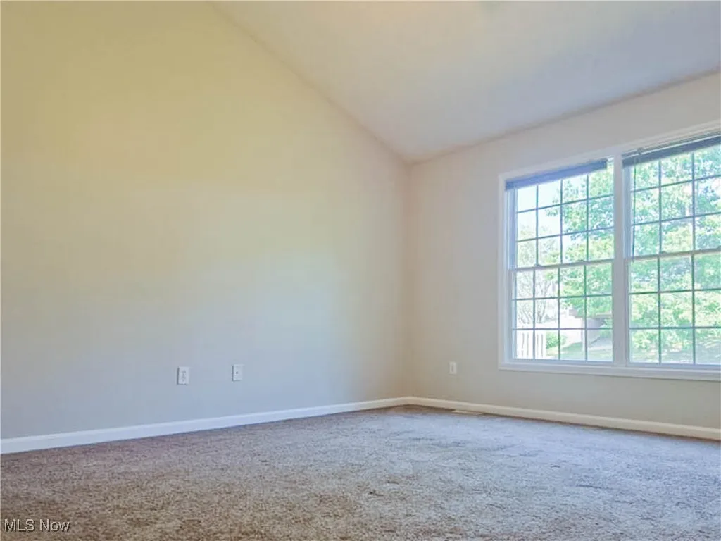 Bedroom featuring lofted ceiling and carpet floors