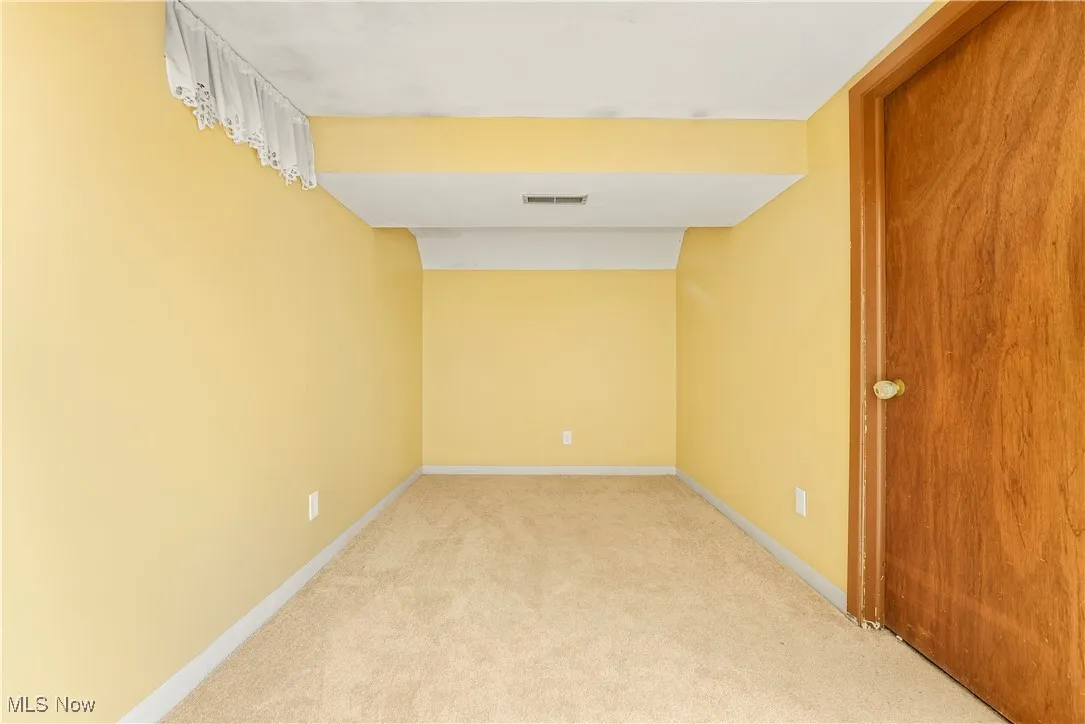 Unfurnished room featuring light colored carpet and baseboards