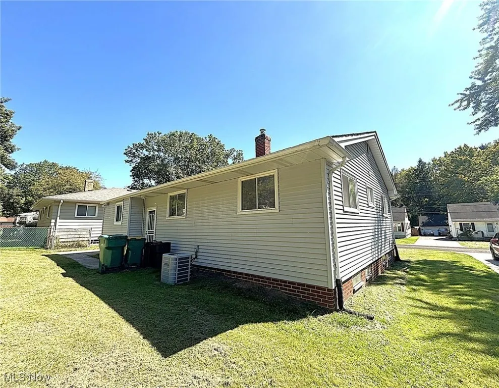 Rear view of house featuring a yard and a chimney