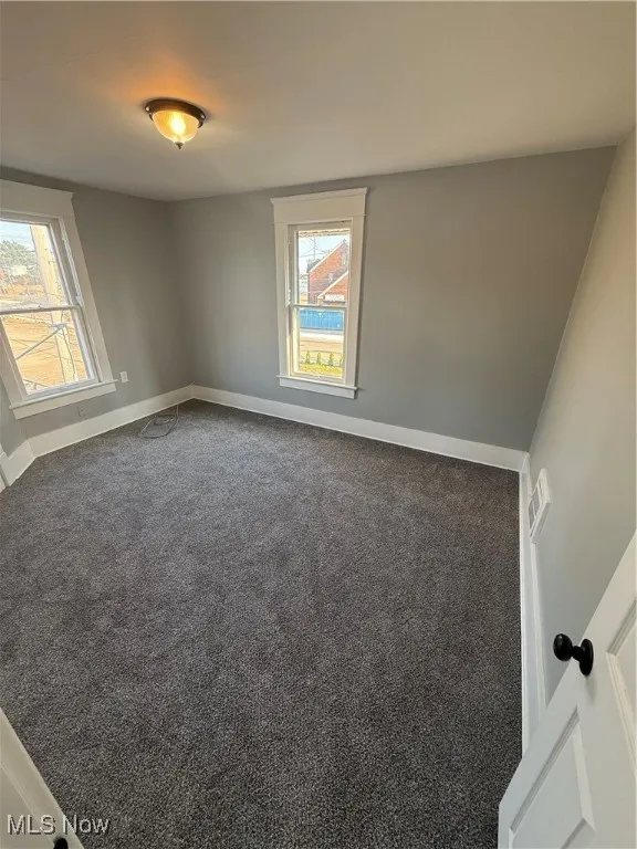 Unfurnished room with carpet flooring and baseboards