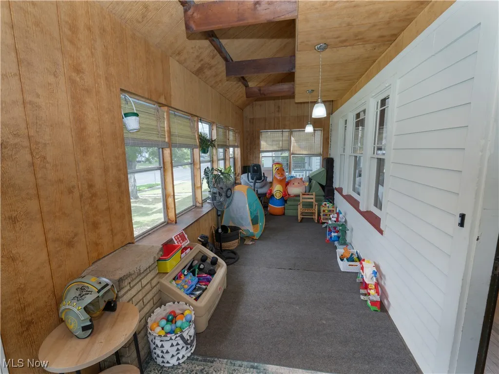 Sunroom / Enclosed front porch with wooden walls, carpet floors, and wooden ceiling