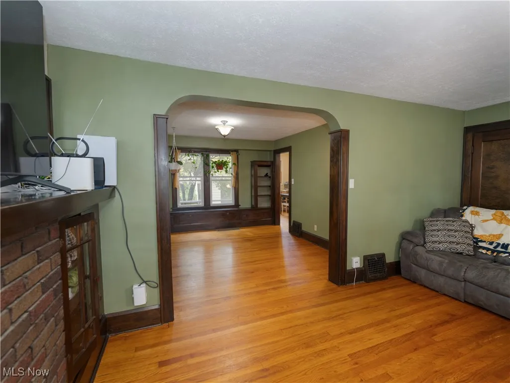 Living room view showcasing arched walkways, and a wood floors