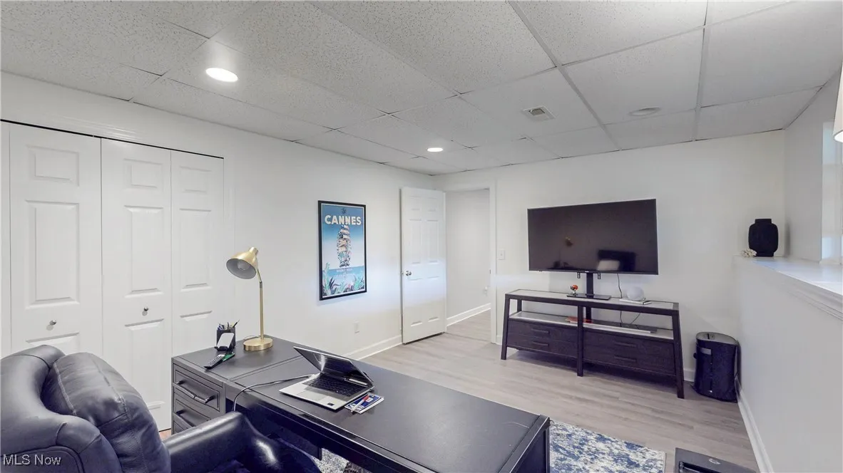 Office space featuring light wood-style flooring, recessed lighting, and a paneled ceiling