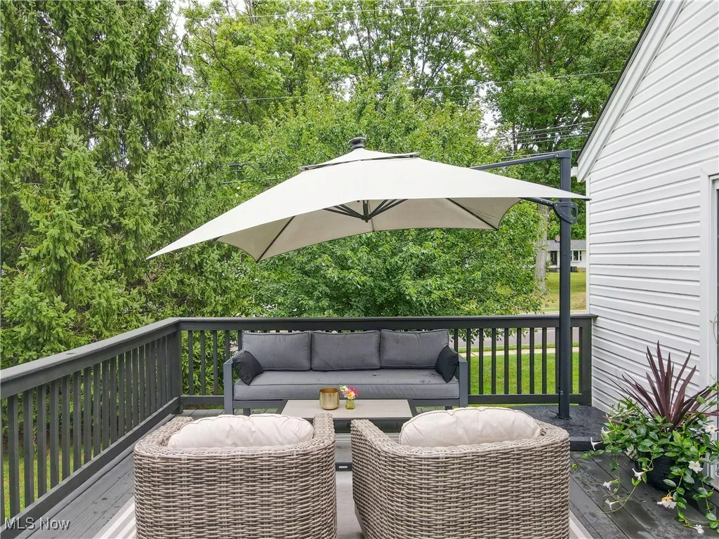 Wooden terrace featuring an outdoor hangout area and view of scattered trees