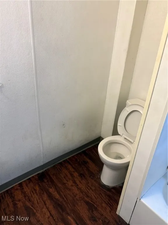 Bathroom with dark wood finished floors and a tub to relax in