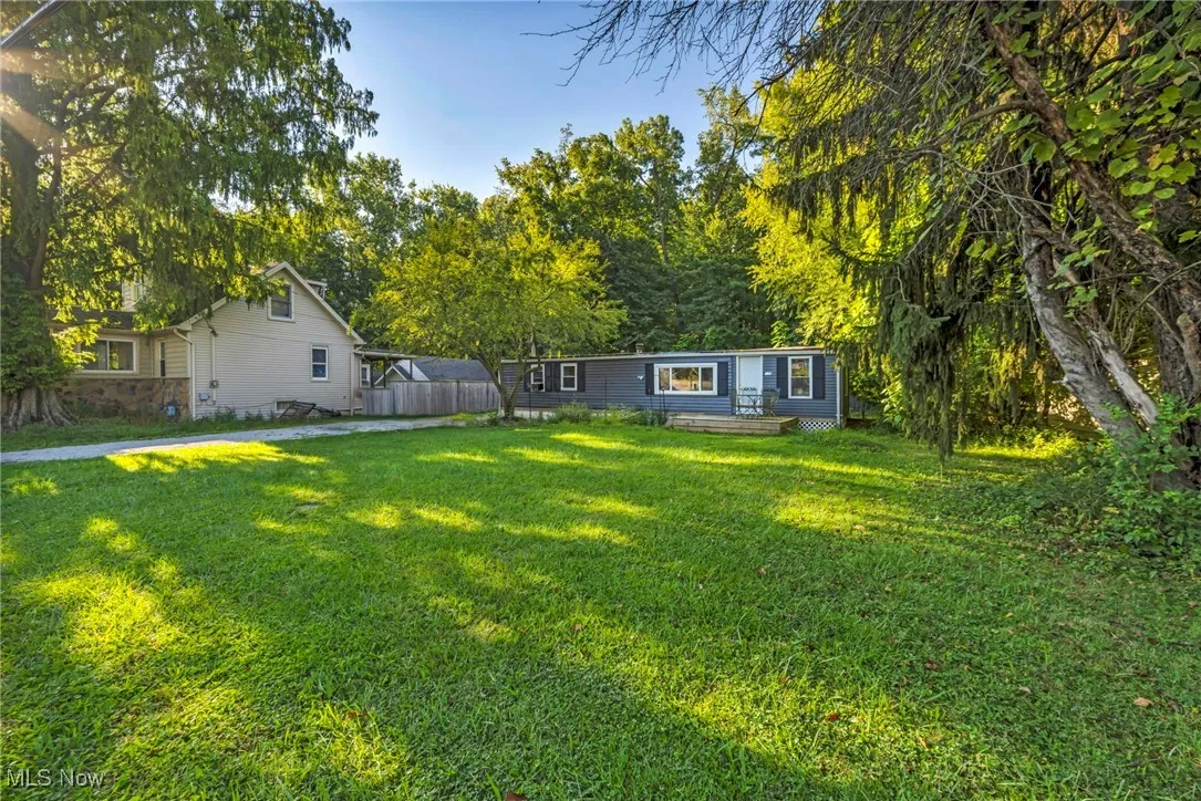 View of green lawn featuring view of wooded area