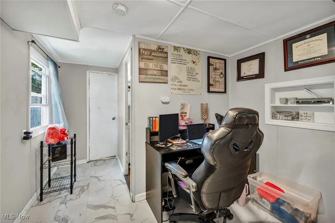 Home office featuring light marble finish flooring and baseboards