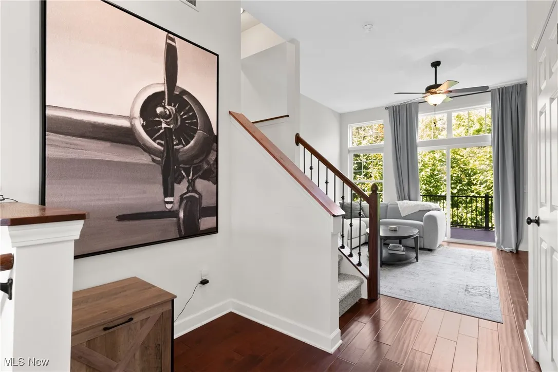 Stairs featuring wood finished floors and ceiling fan
