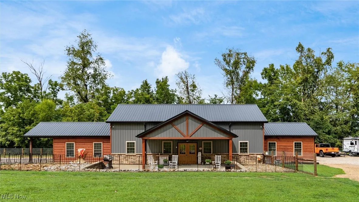 Back of property with a patio area, a metal roof, french doors, and log veneer siding