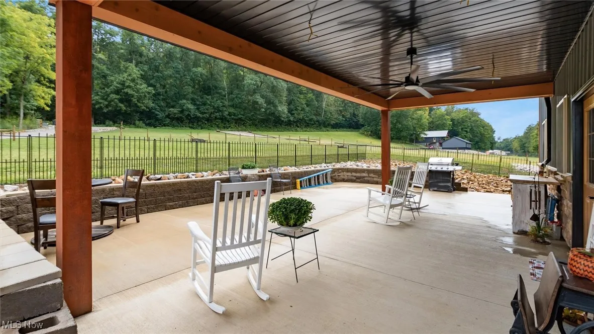 Fenced backyard featuring ceiling fan, a patio, and area for grilling