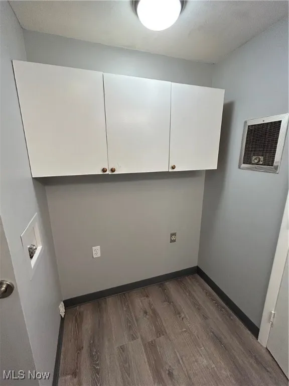 Washroom featuring cabinet space, dark wood-type flooring, and hookup for a washing machine