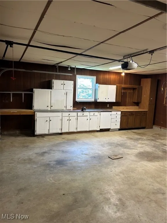 Garage featuring wooden walls and a garage door opener