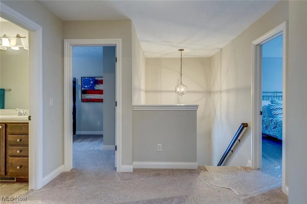 Corridor with an upstairs landing and carpet floors