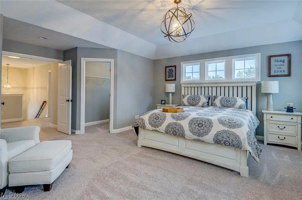 Bedroom featuring a spacious closet, carpet flooring, and a chandelier