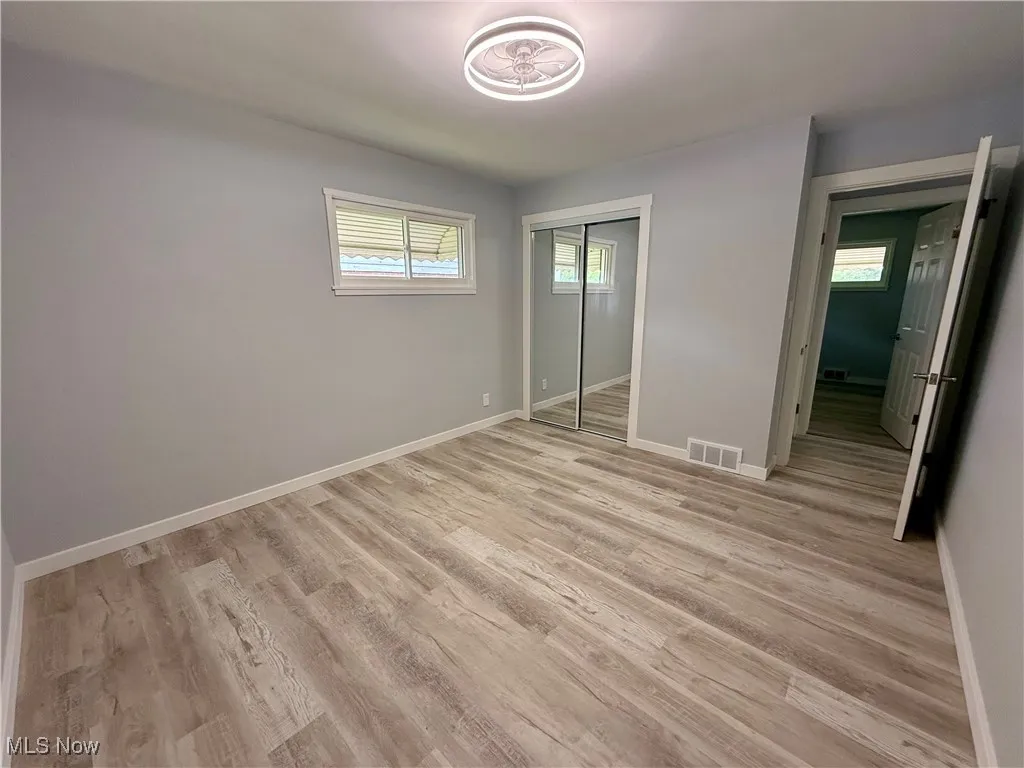 Unfurnished bedroom with light wood-style flooring and a closet