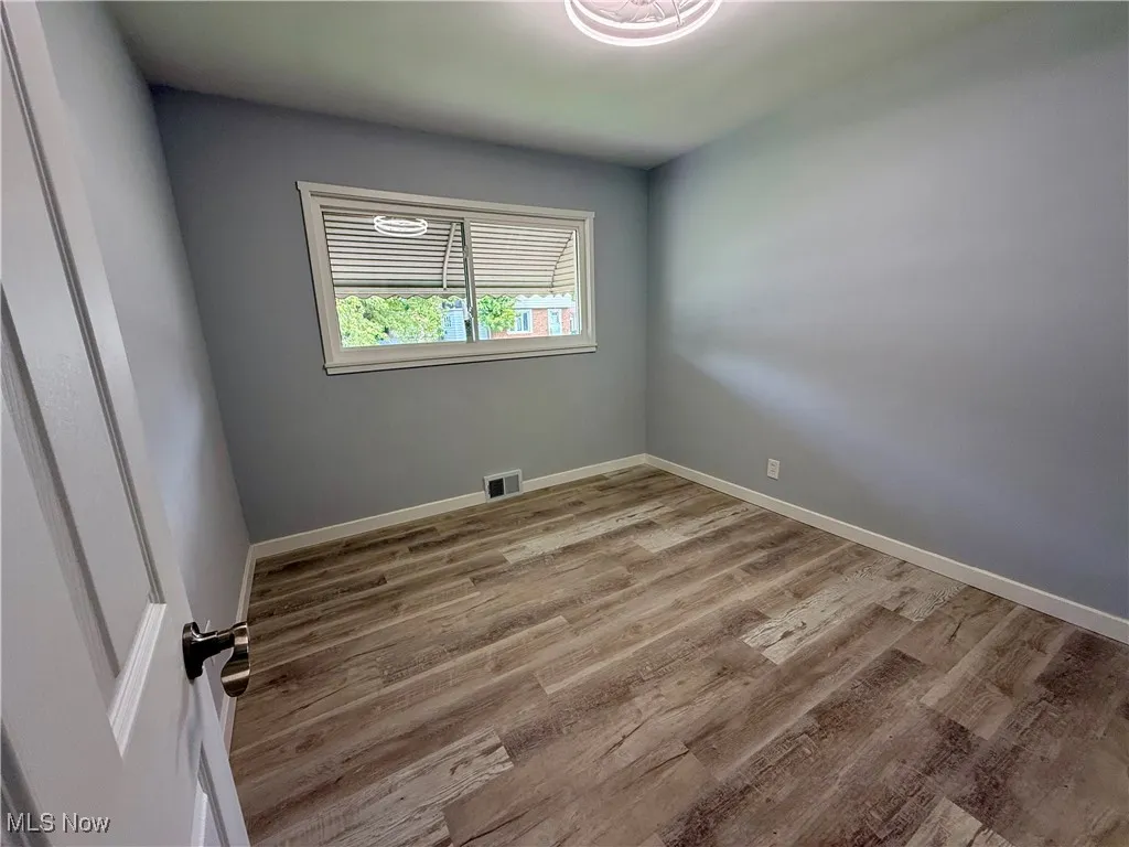 Unfurnished room with light wood-style flooring and baseboards