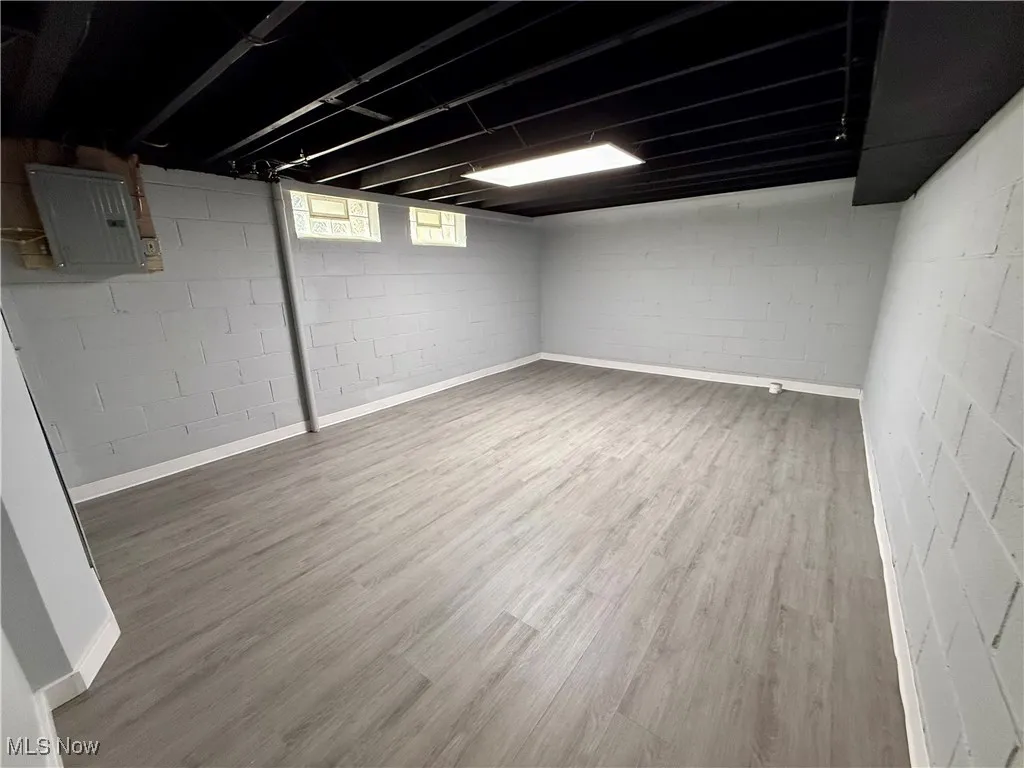 Basement with wood finished floors and electric panel