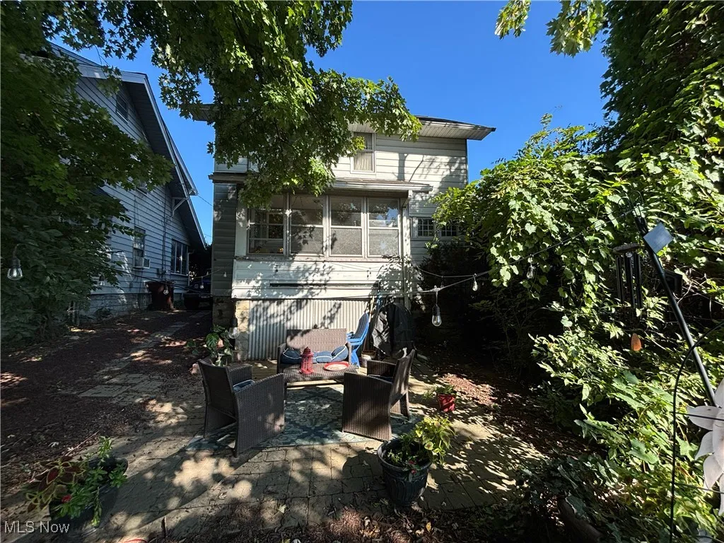 Back of house with a sunroom and a patio area