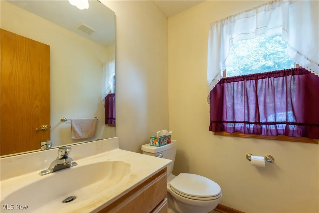 Half bathroom featuring vanity and toilet