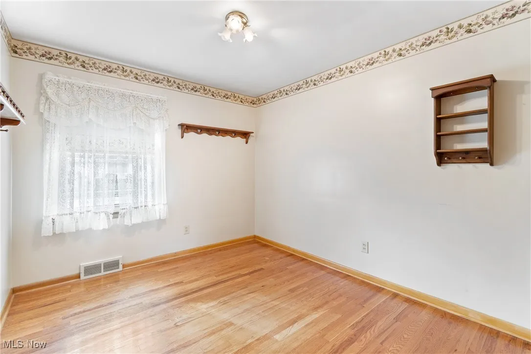 Empty room featuring light wood-type flooring and baseboards