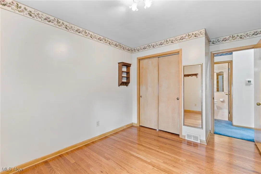Unfurnished bedroom featuring light wood finished floors and a closet