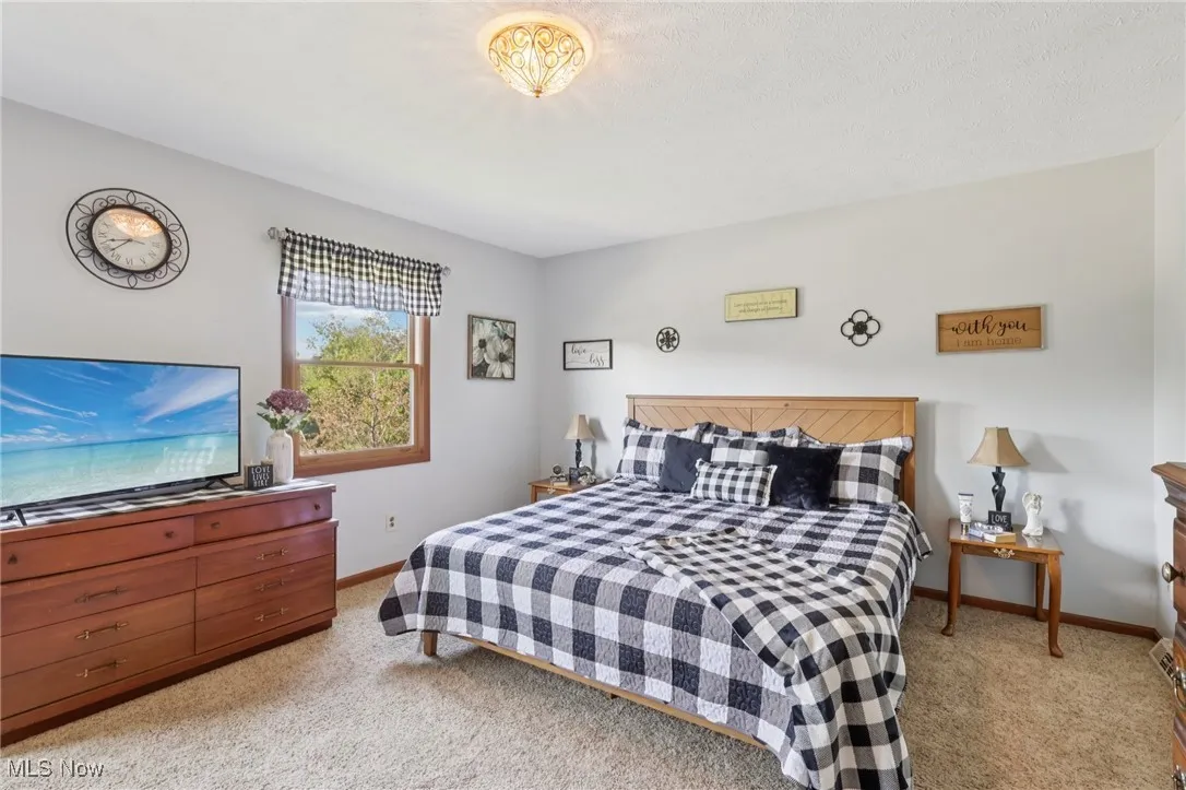 Bedroom featuring light carpet and baseboards