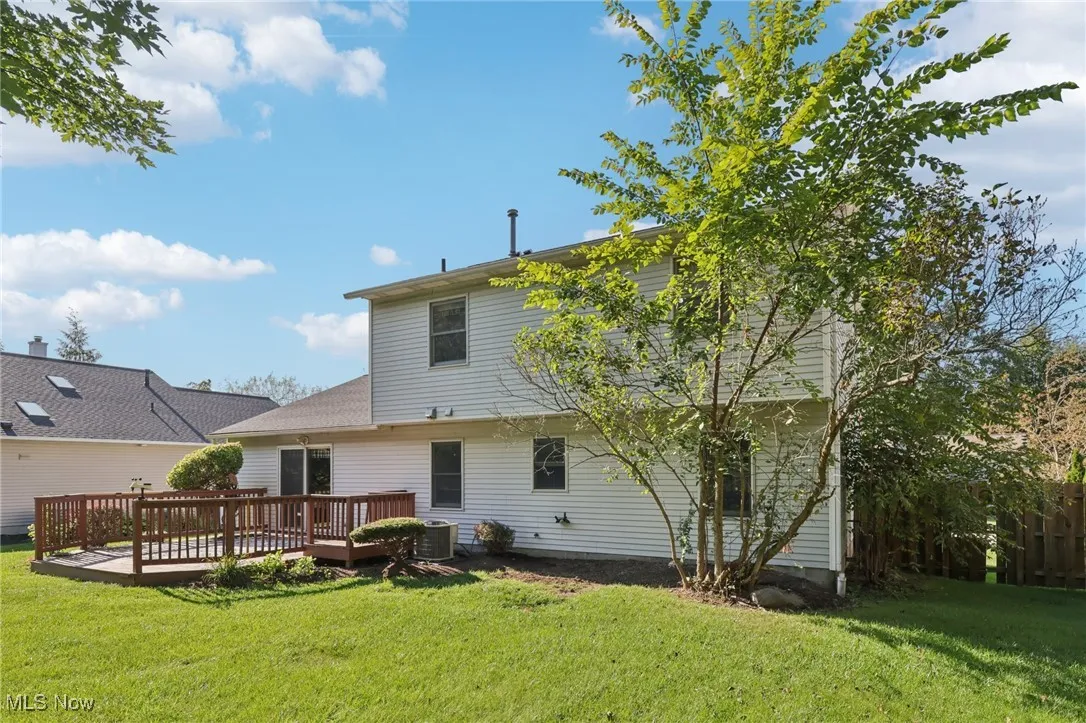 Rear view of house featuring a deck and a yard