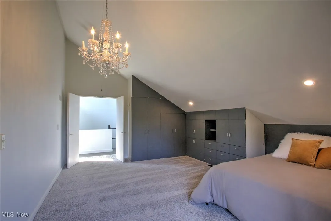 Bedroom featuring carpet floors, a closet, a chandelier, and high vaulted ceiling
