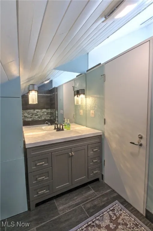 Bathroom with vanity and tasteful backsplash