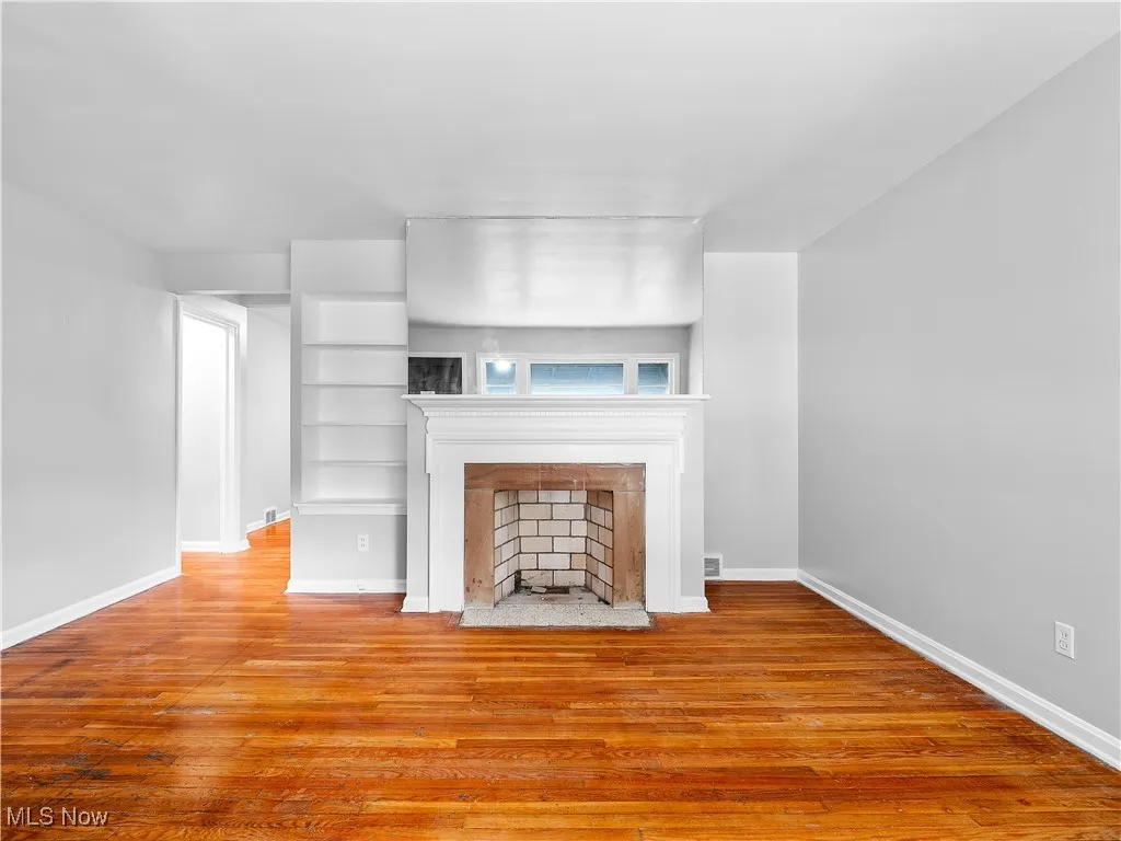 Unfurnished living room with hardwood / wood-style floors and a fireplace with flush hearth