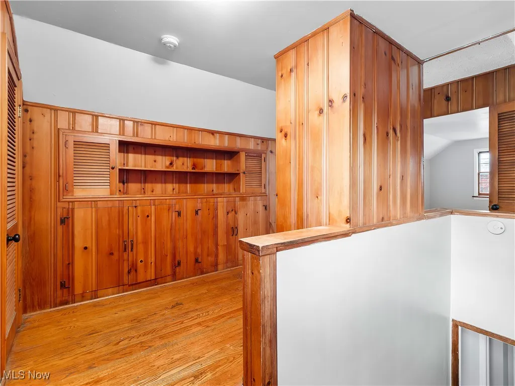 Bonus room featuring wooden walls and light wood-style floors