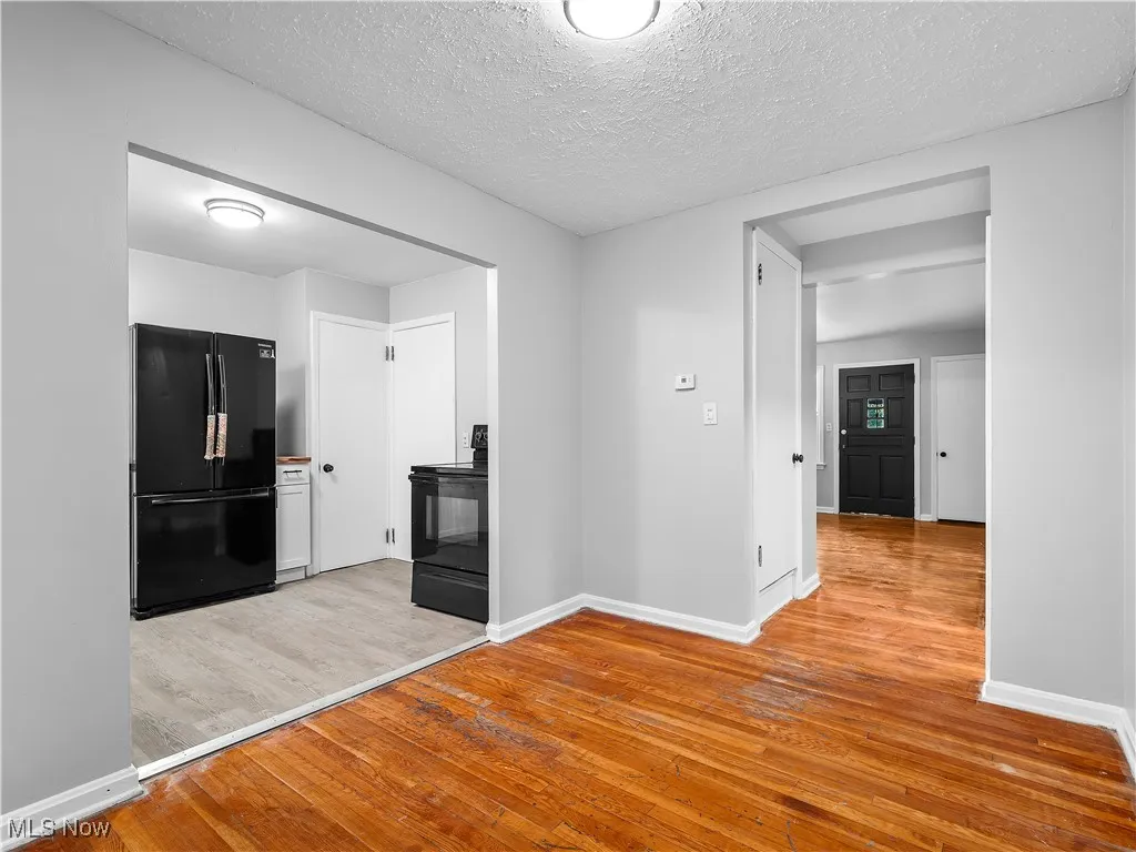Corridor featuring light wood-type flooring and a textured ceiling