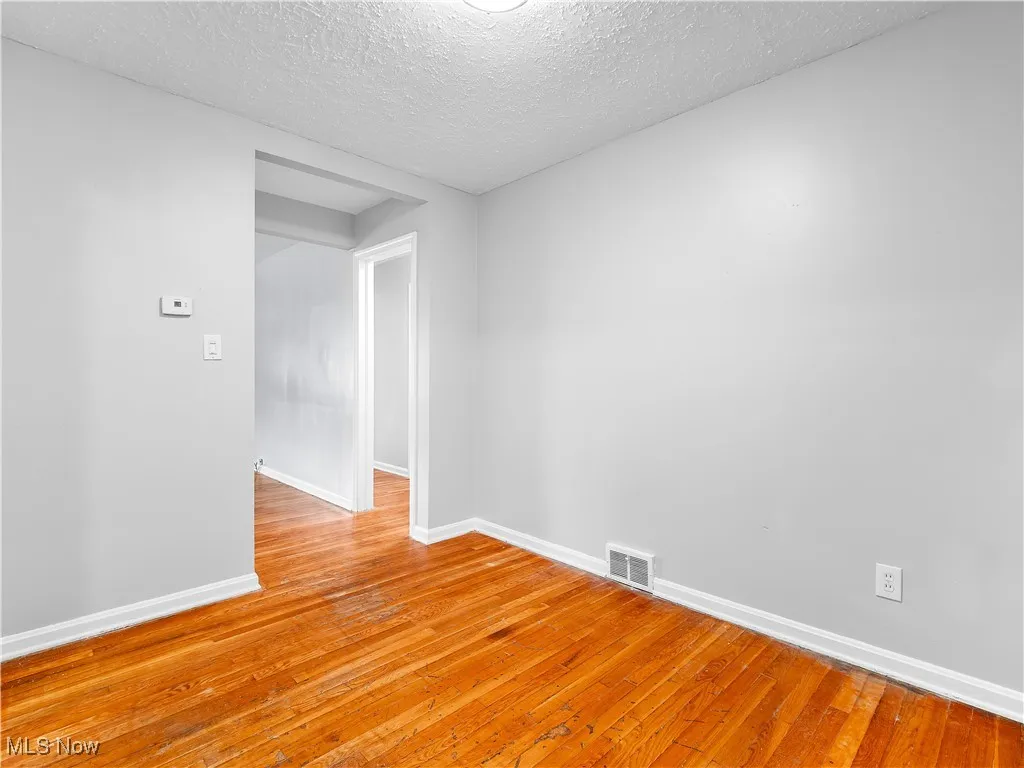 Spare room with light wood-style floors and a textured ceiling