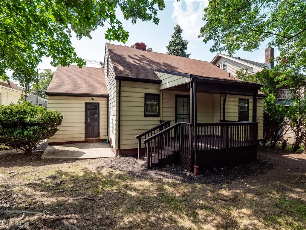 View of front of house featuring a patio area, a chimney, and a shingled roof