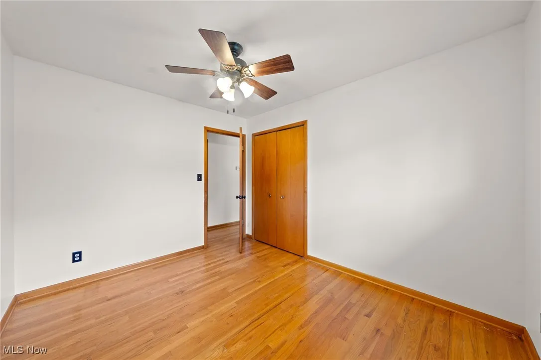 Spare room with light wood finished floors and ceiling fan