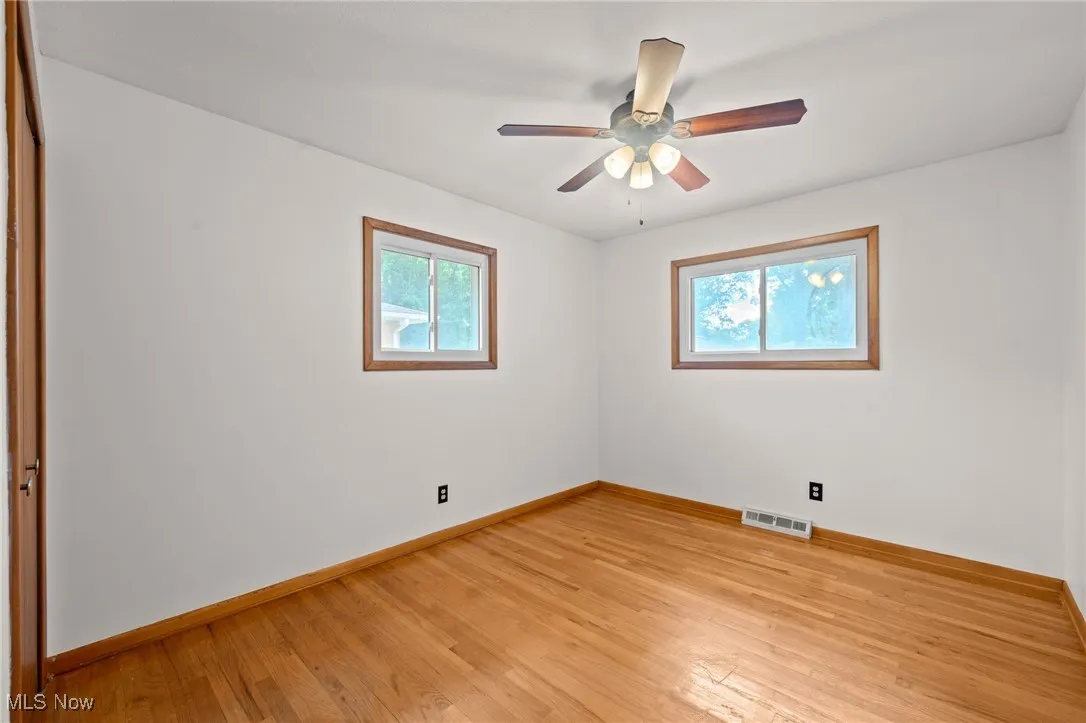 Unfurnished bedroom with light wood-type flooring, a ceiling fan, and a closet