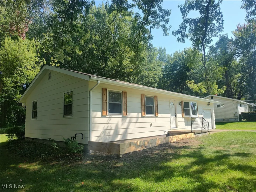 Ranch-style house with a front yard, an attached garage, and crawl space