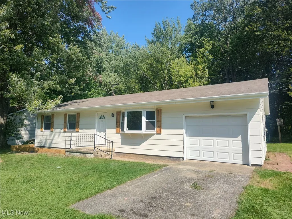 Ranch-style home featuring a front lawn and driveway