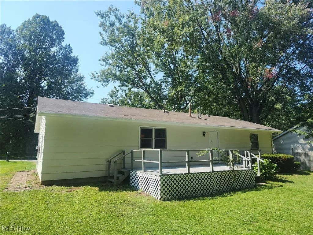 Back of property featuring a yard and a deck