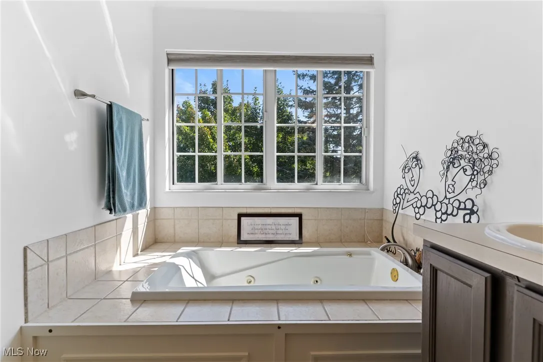 Full bathroom featuring a whirlpool tub and vanity